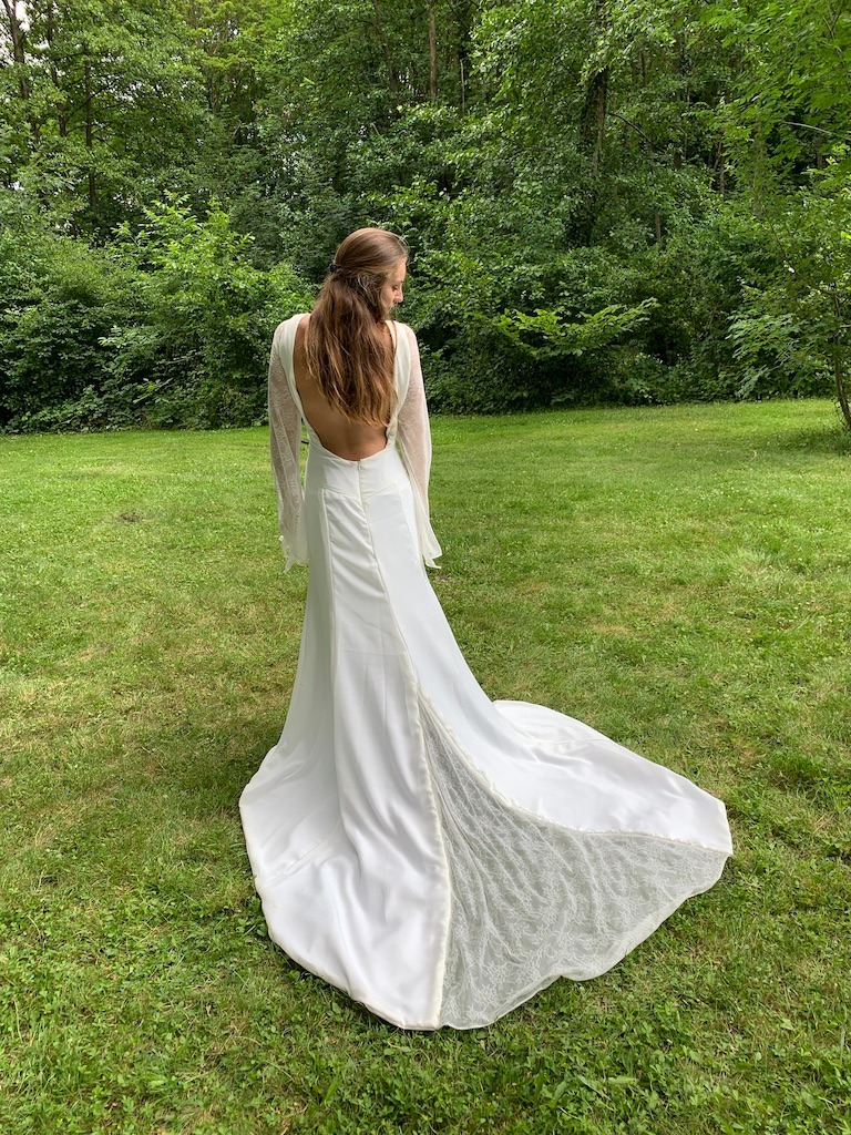 a woman in a white dress standing in the grass