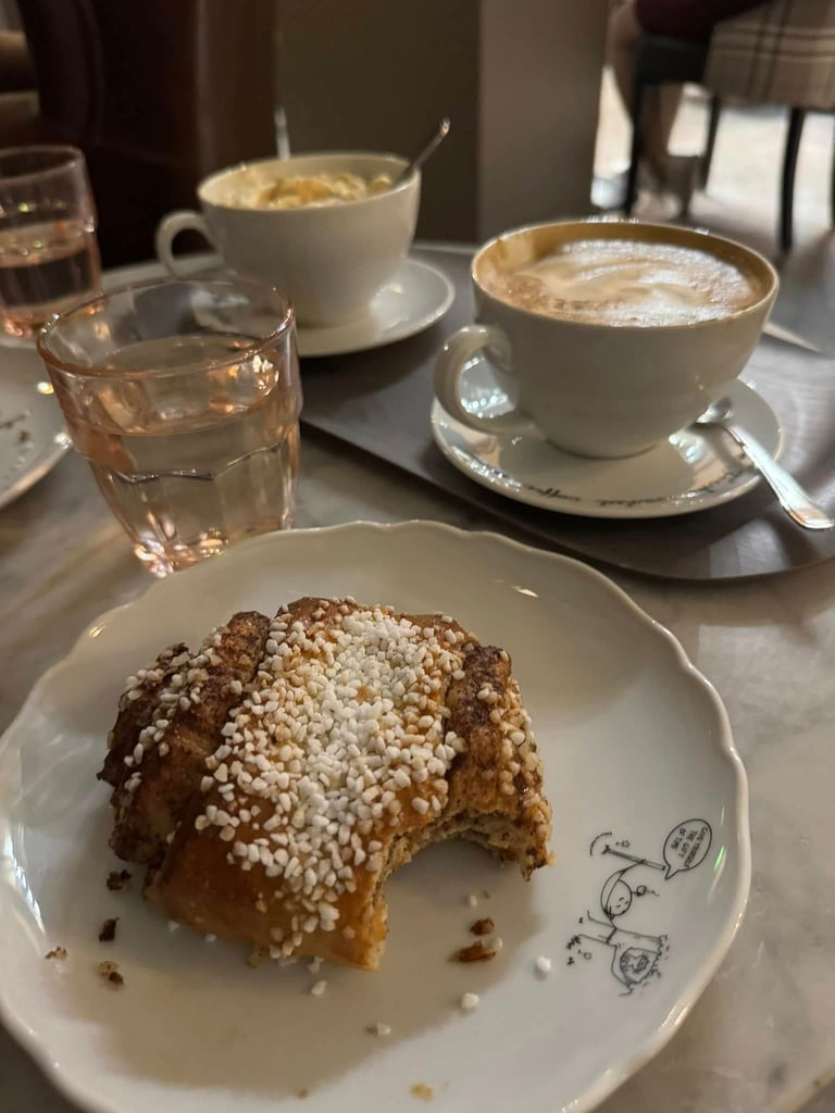 a coffee and a pastry with a bite taken out of it