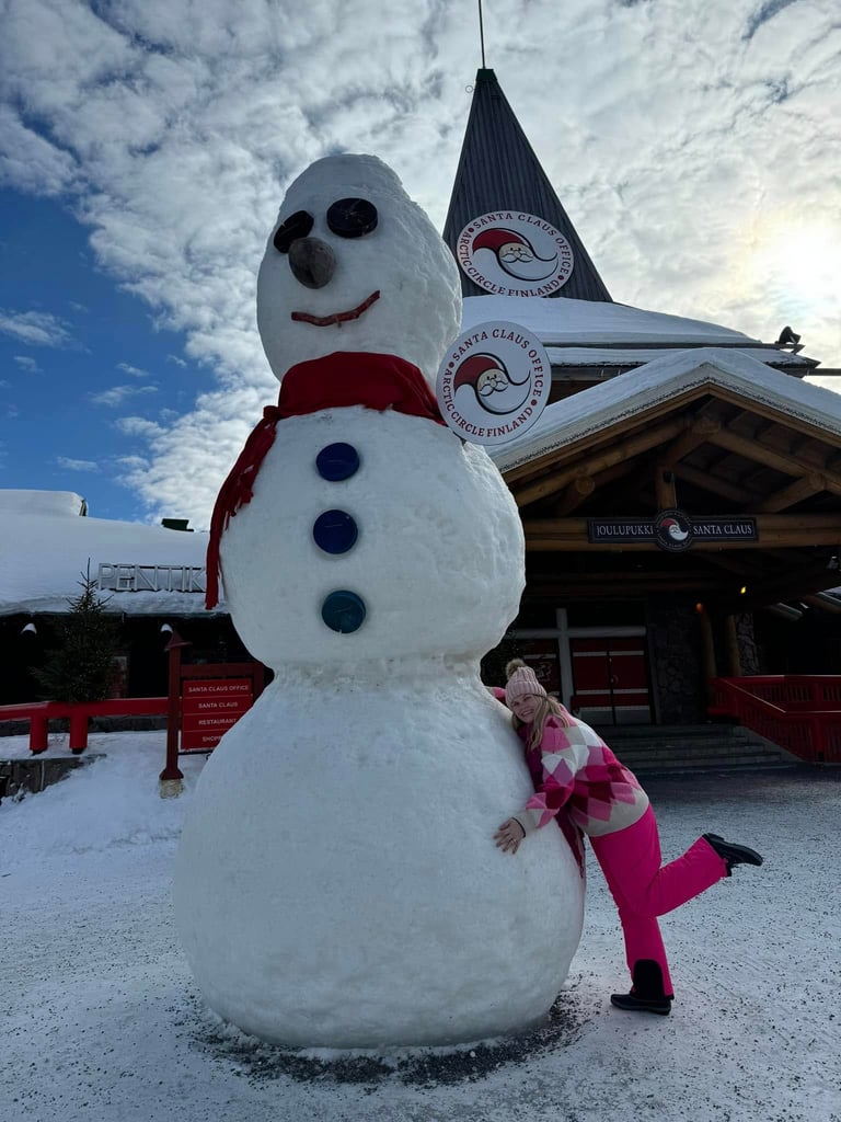 A tourist hugs a giant snowman at Santa Claus Village in Rovaniemi, Lapland, Finland.