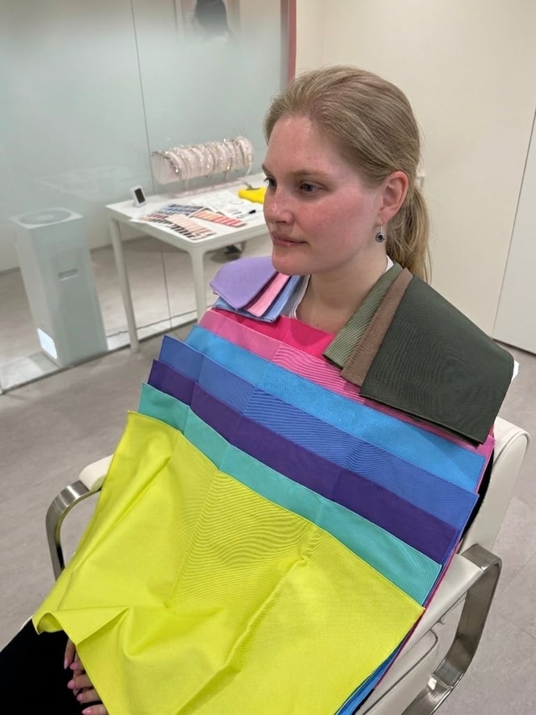 A woman receives a personal color analysis session with various fabric drapes used to find her seasonal palette.