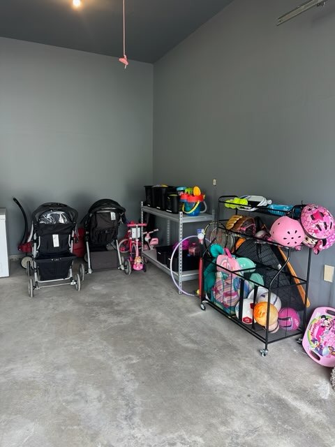 an organized garage space with sports equipment and strollers