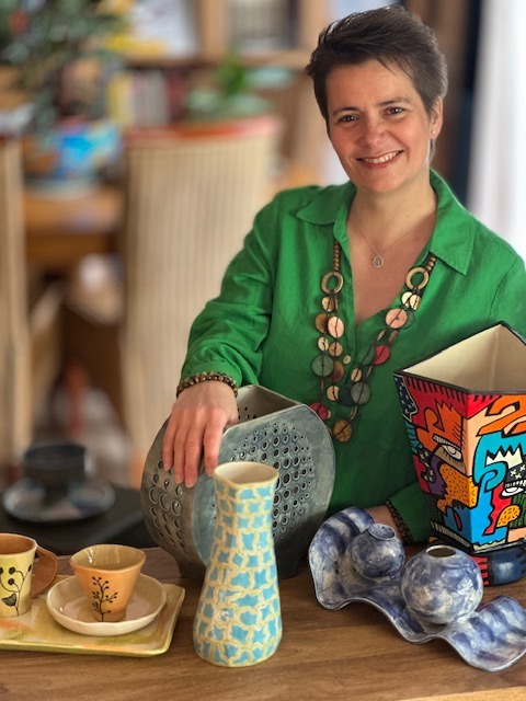 La céramiste Elvira avec ses créations céramiquesirt is holding a box of coffee