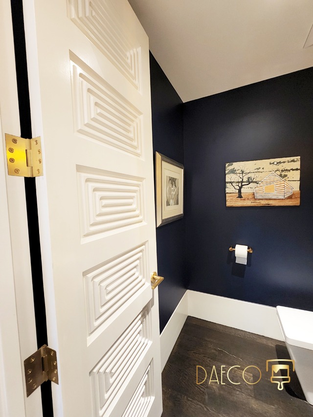 a bathroom with a white door and a blue wall