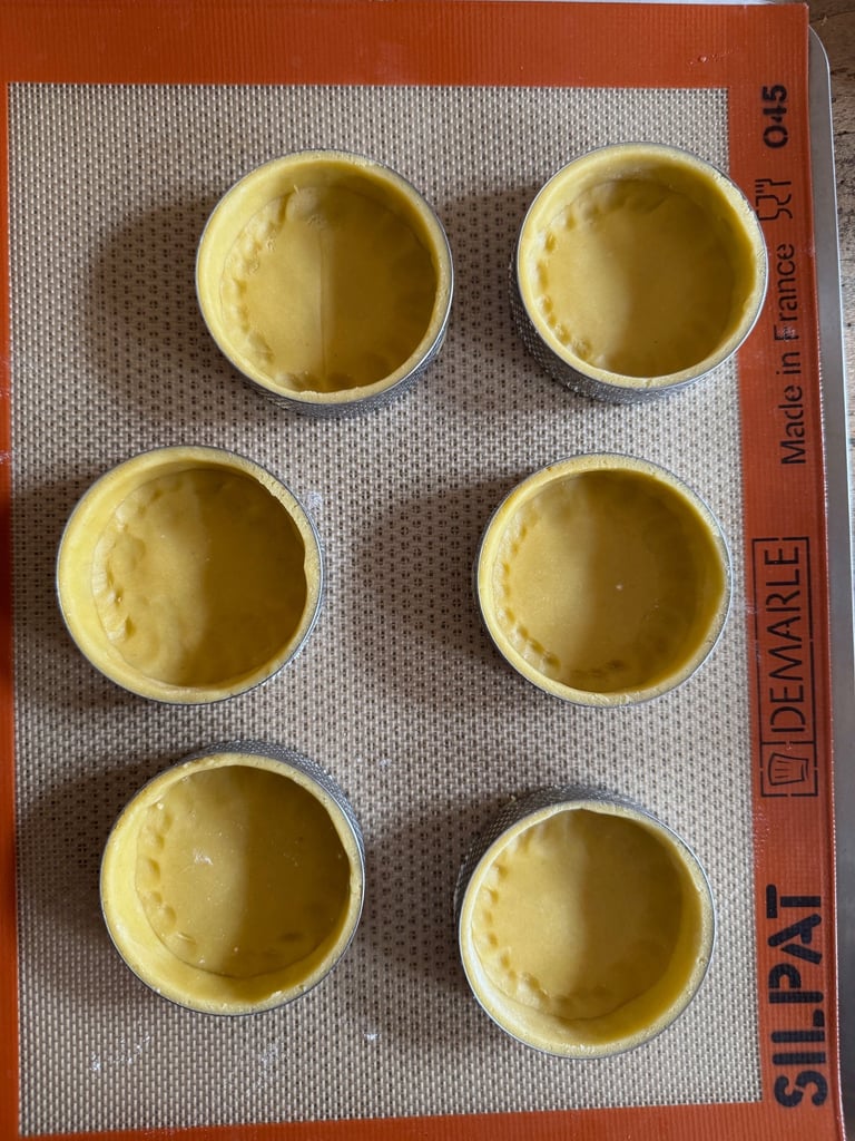 a baking tray with four cups of food and a measuring scale