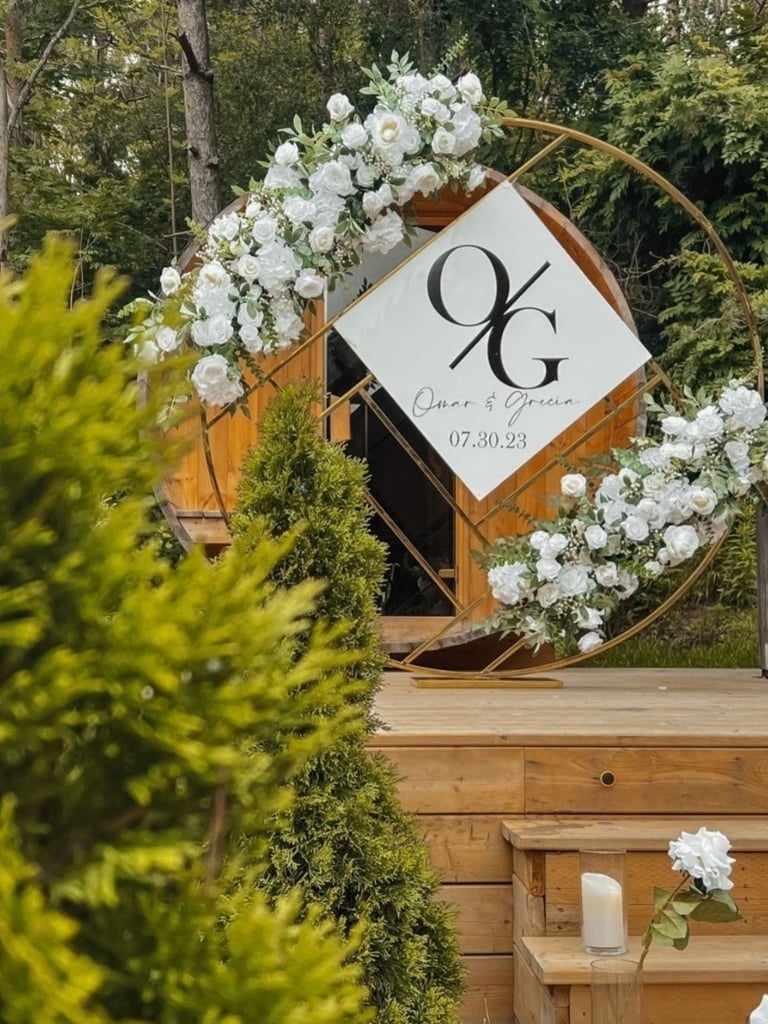 wedding ceremony gold chrome circle backdrop with white floral arrangements