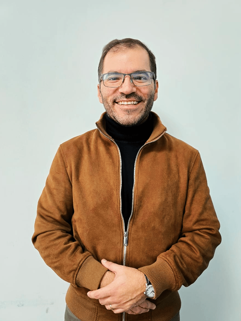 a man in a brown jacket and glasses