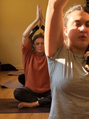 2 ladies performing a yoga pose