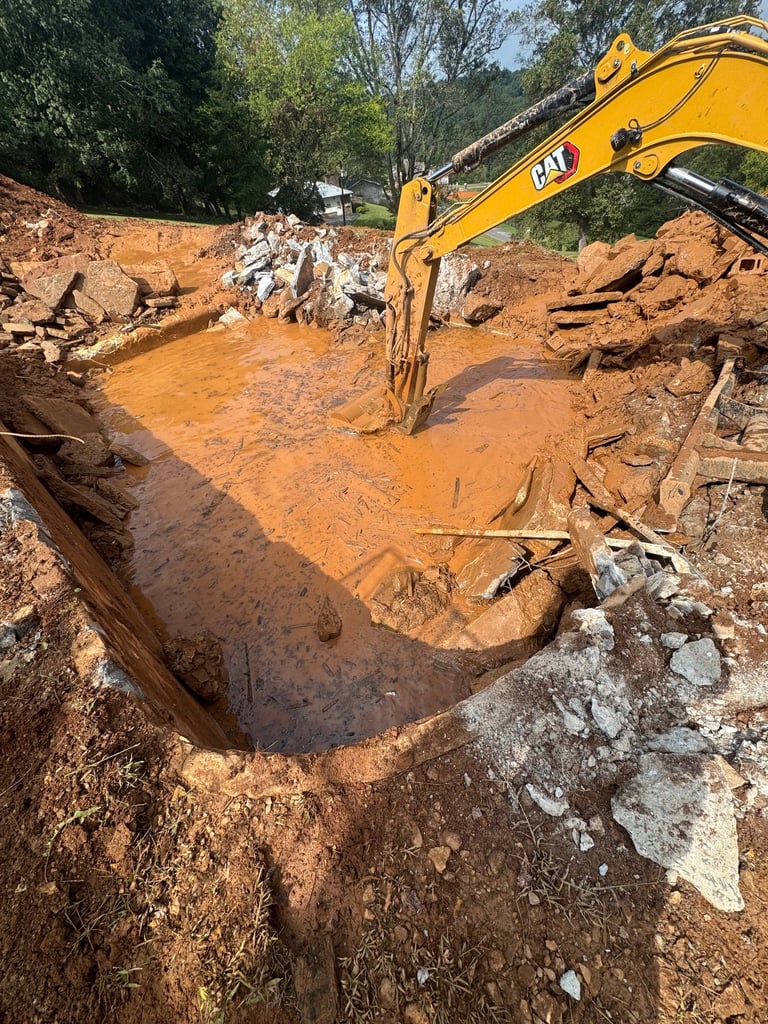 excavator digging out concrete pool