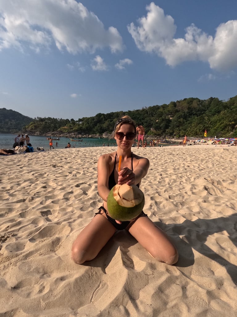 kobieta w bikini z kokosem na plaży w Tajlandii