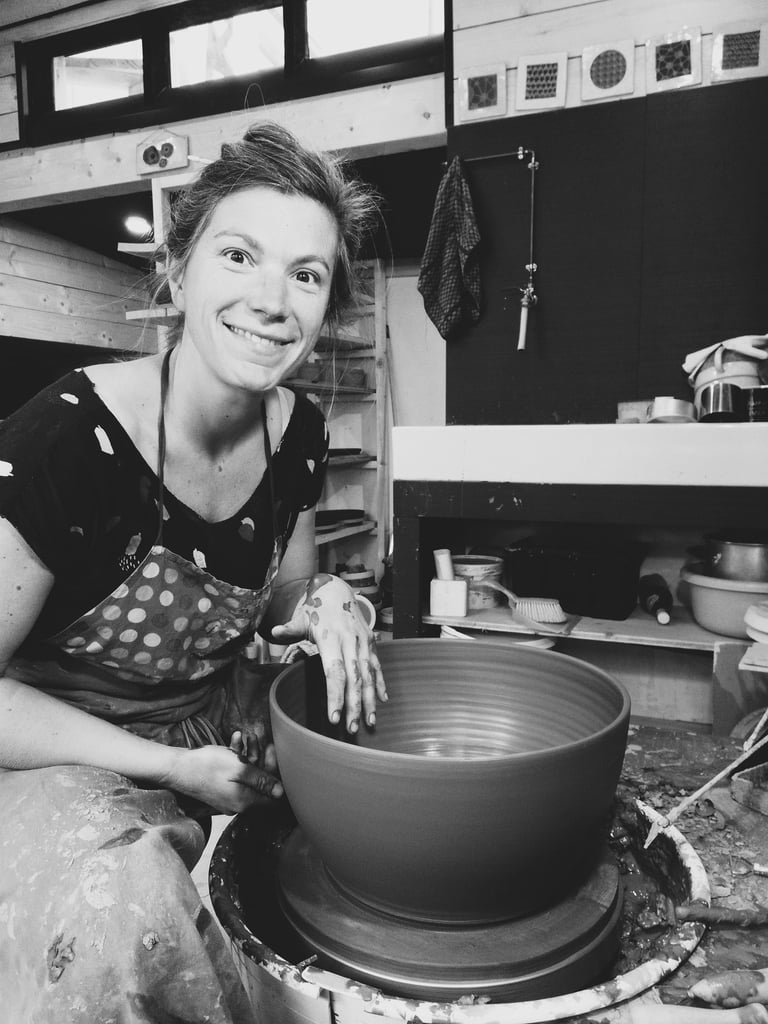une femme en train de tourner un saladier sur un tour de poterie