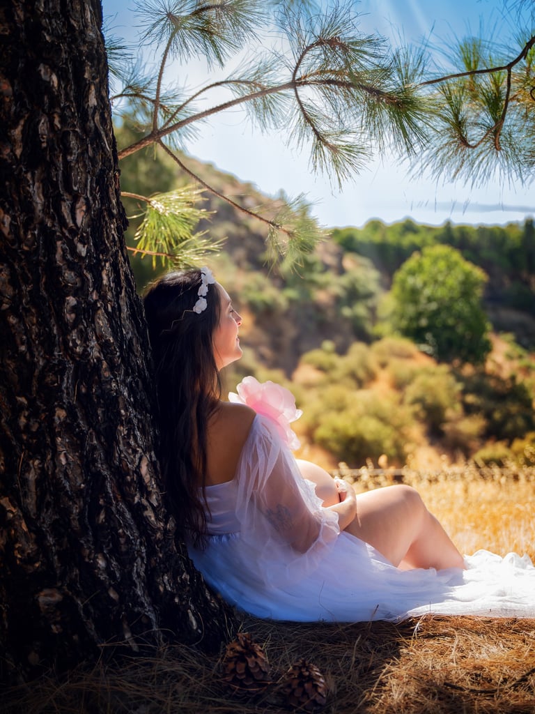 a woman sitting on a tree trunk trunk trunk trunk trunk trunk trunk trunk trunk trunk