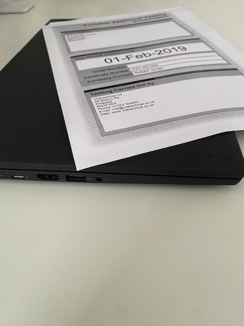 a laptop computer sitting on a desk with a paper document