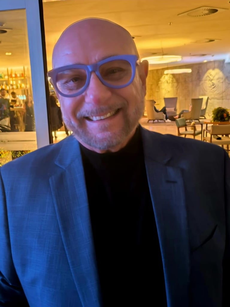 a man in a suit and glasses smiling