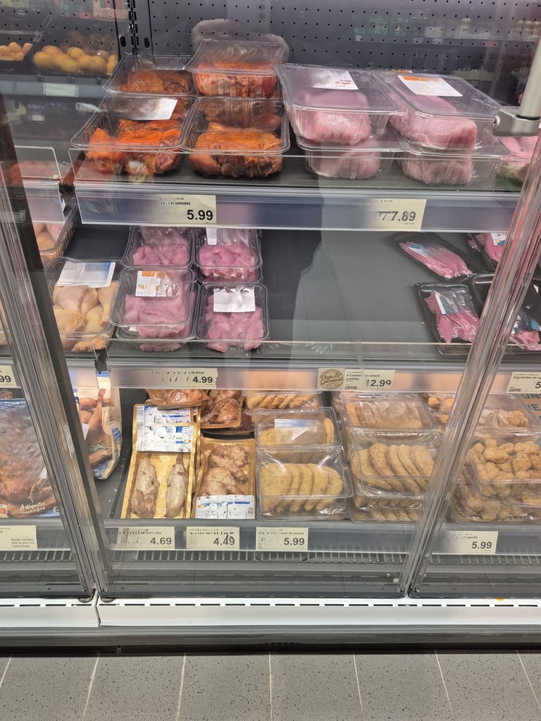 Das Bild zeigt ein Kühlregal mit sehr viel billigem und abgepacktem Fleisch