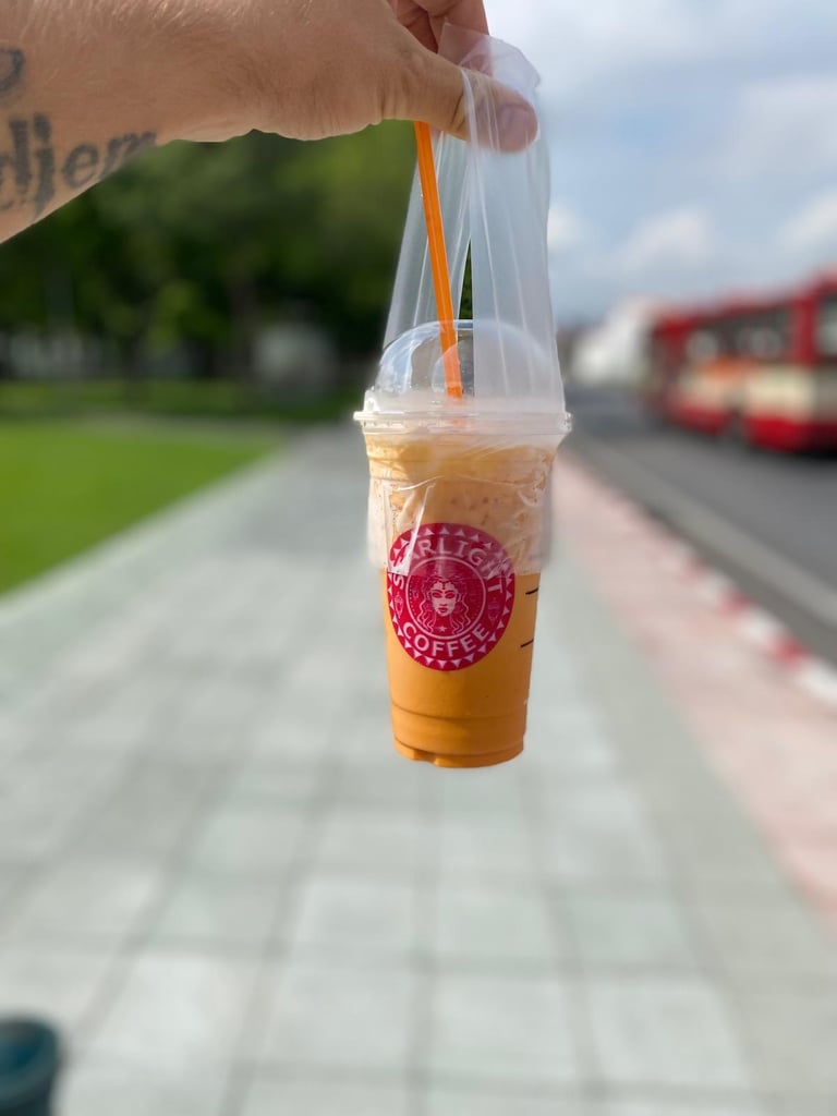 a person holding a cup of coffee in a plastic cup