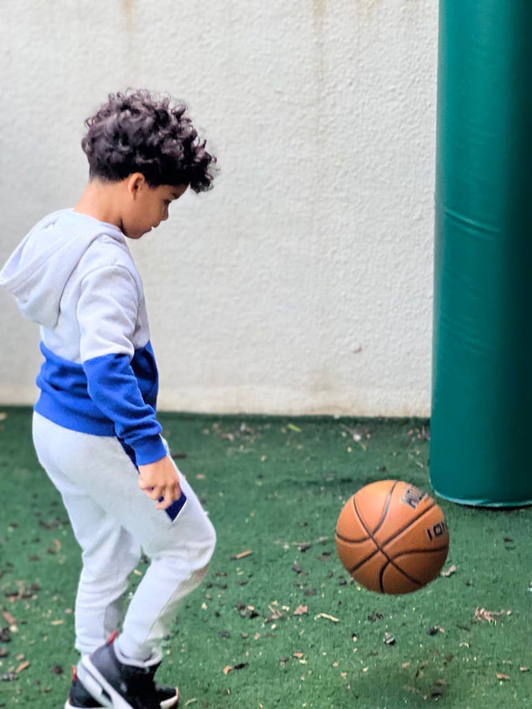 a young boy playing with a basketball ball FANTASTIC LAND LEARNING CENTER