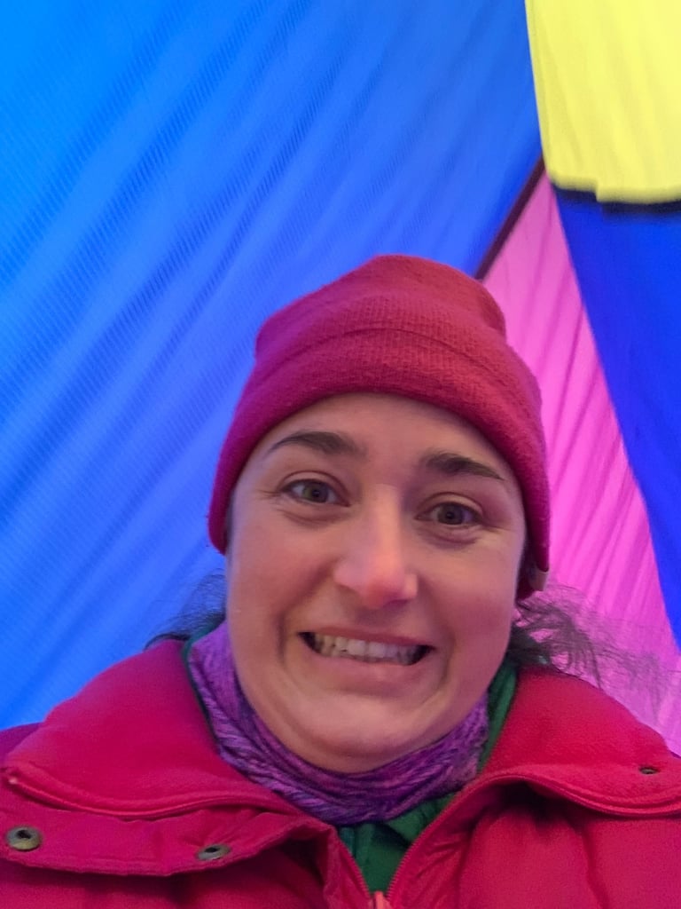 Kayla Brooks standing between hot air balloons and looking excited
