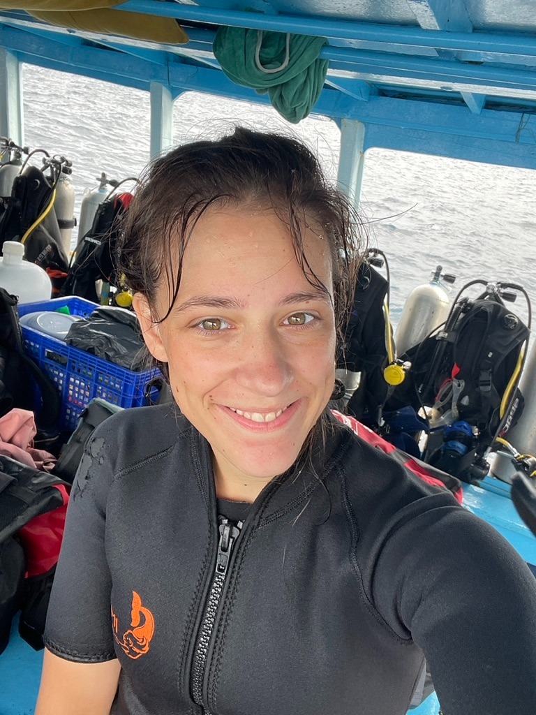 a woman in a wetsuit is smiling and was scuba diving