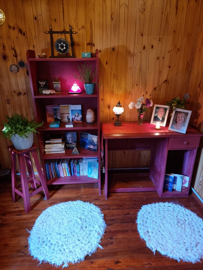 Escritorio con fotos y lampara dentro de una cabaña de madera, lugar de trabajo de Mariel Hilgert