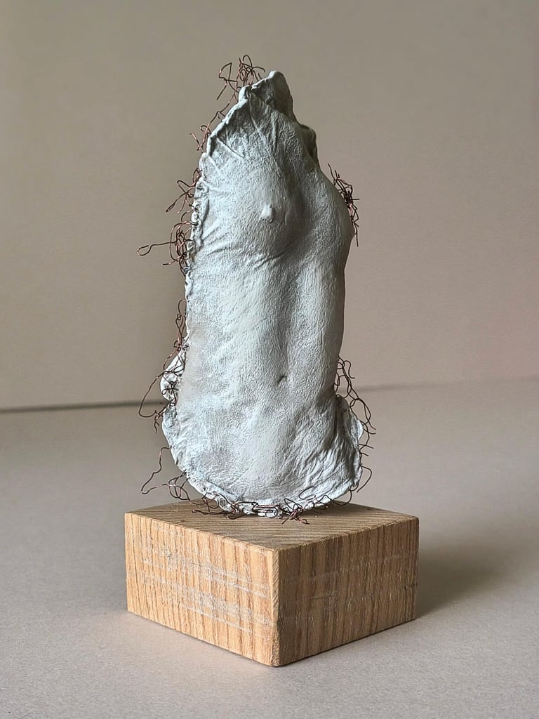 A plinth mounted sculpture of a female torso with wire around it and protruding through it.