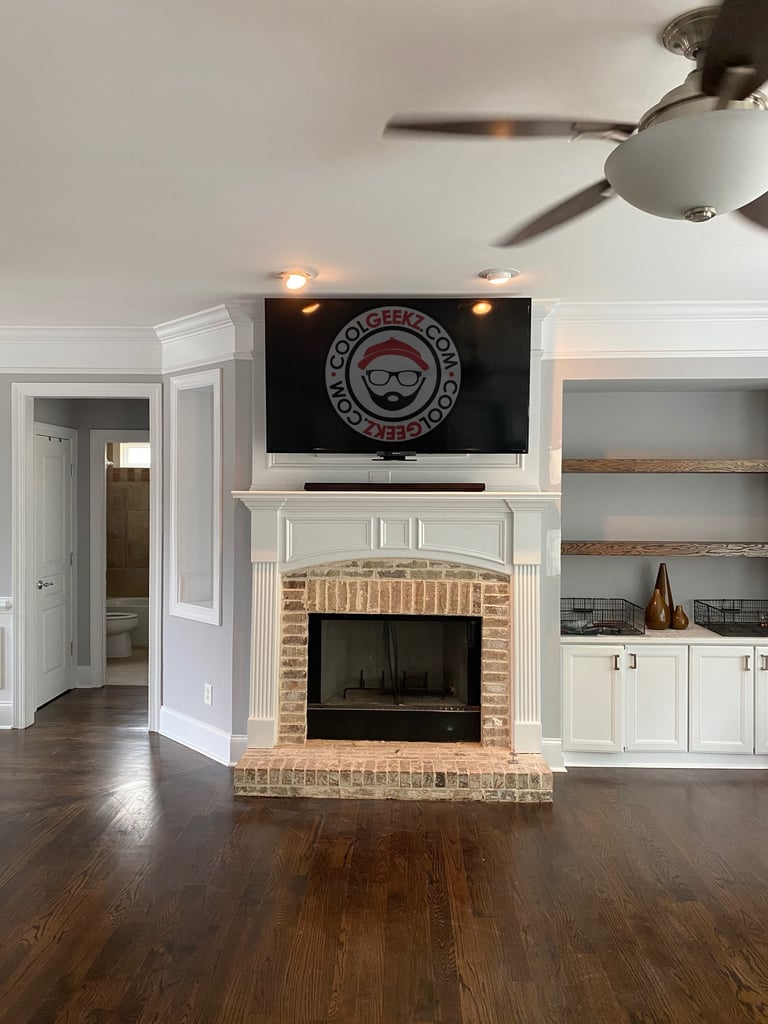 tv installed over a fireplace with hidden wires