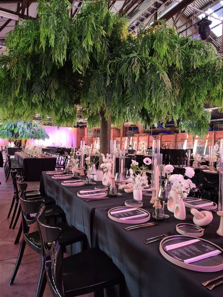 Fake tree in event space with beautiful table decorated of candle and flowers