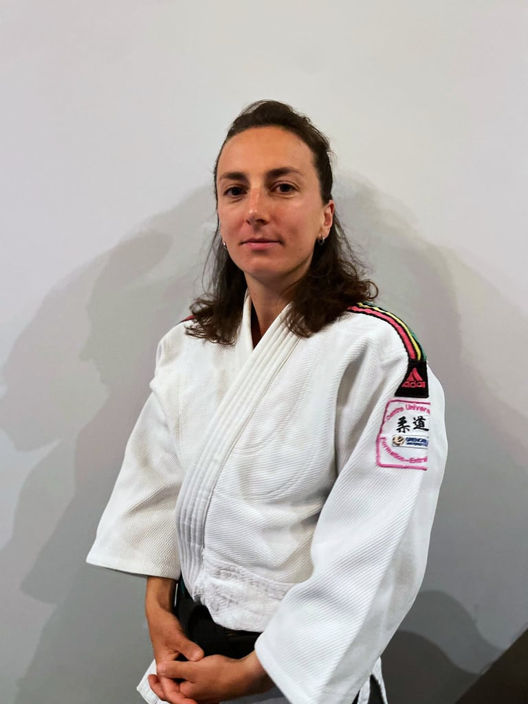 Une femme en kimono de Judo, portant une ceinture noire.