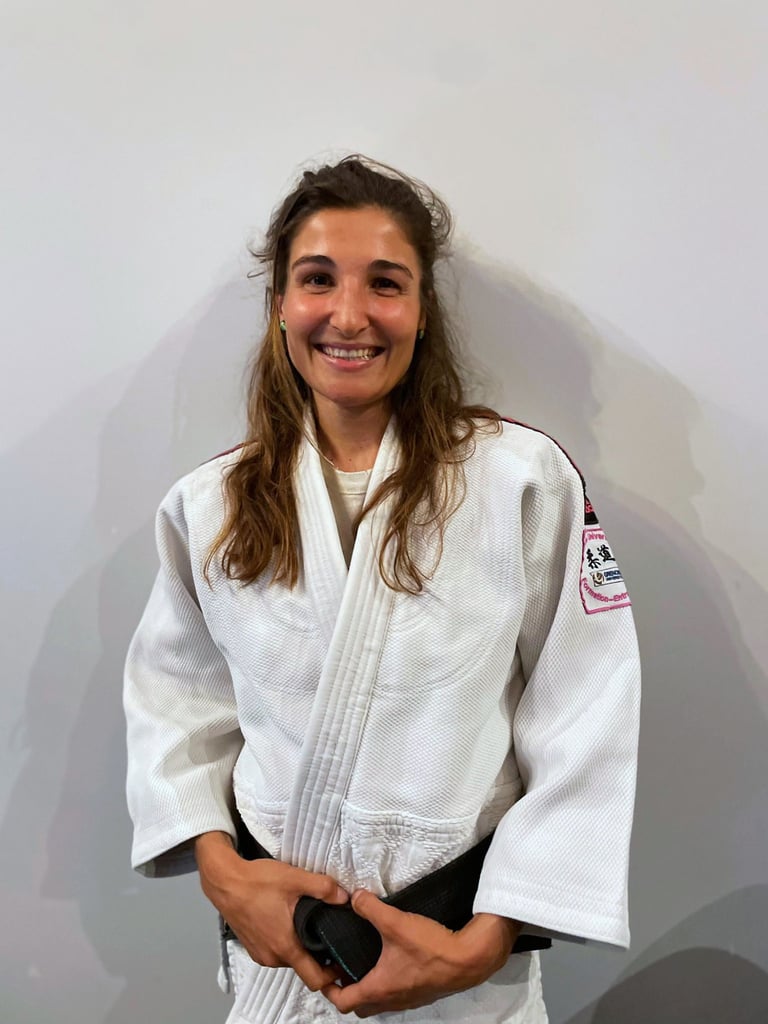 Une femme en kimono de Judo, portant une ceinture noire.
