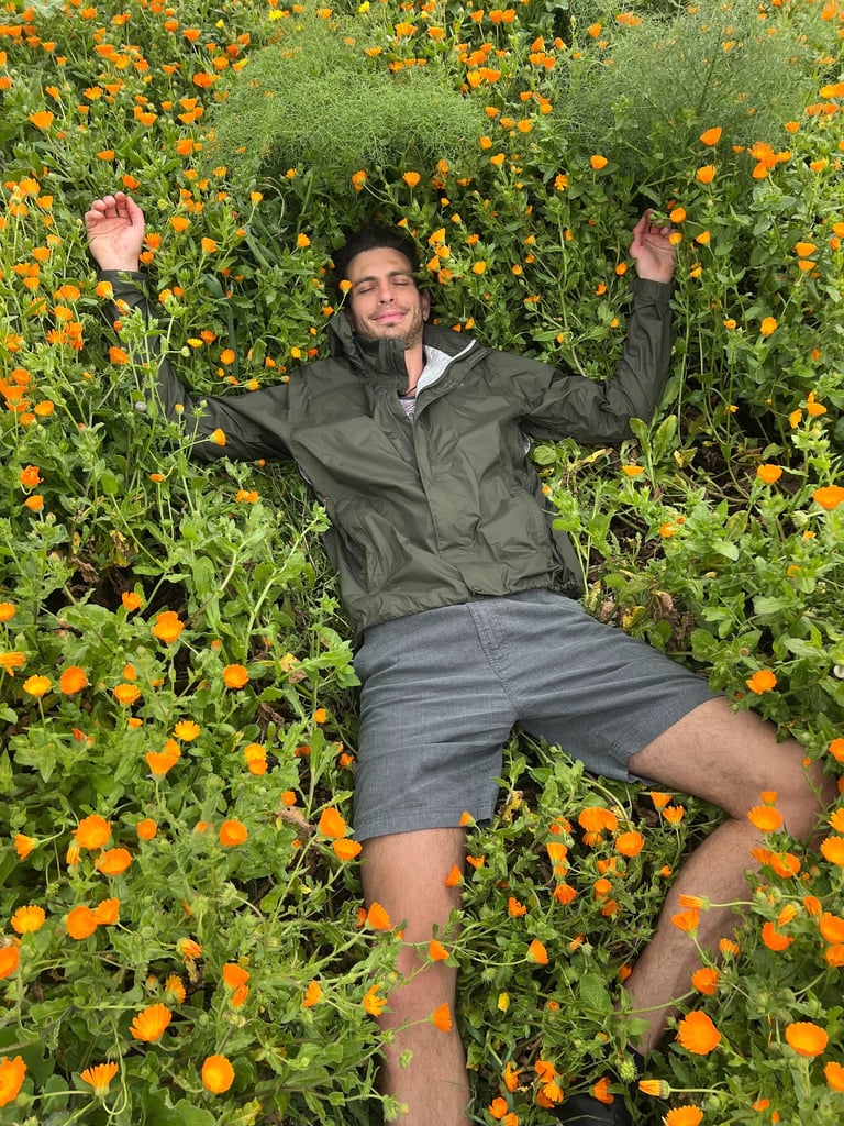 Paul laying down in a field of flowers
