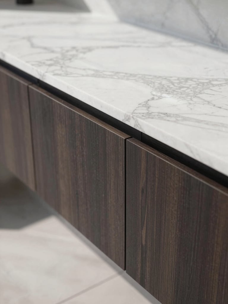 Close-up architectural detail of a premium marble slab meeting custom dark wood millwork with millimeter precision, bright natural daylight, sharp shadows