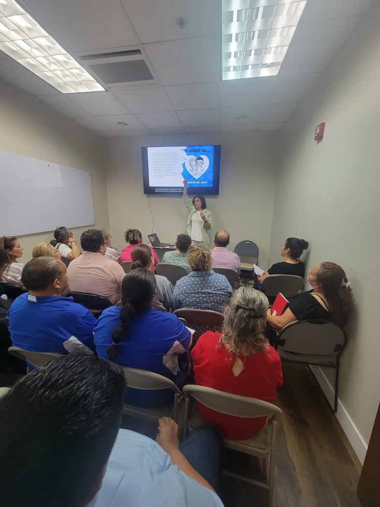 A group of people sitting in a classroom attending a workshop presentation with a female speaker.