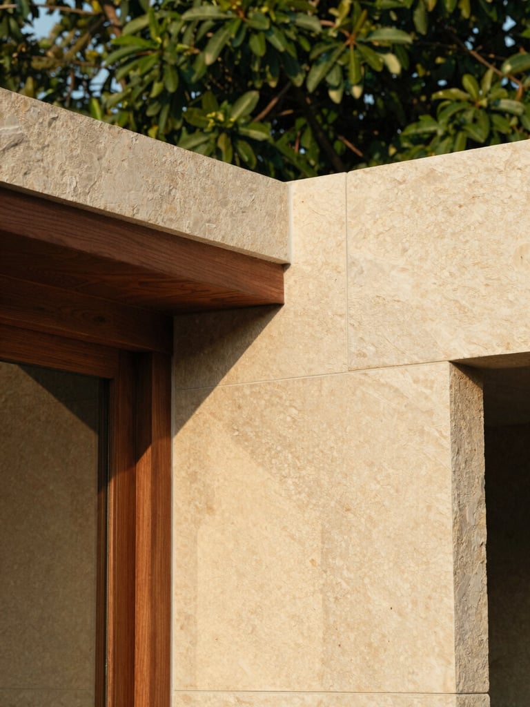 Close-up of natural building materials, warm textured stone and dark wood details under soft morning light, architectural photography