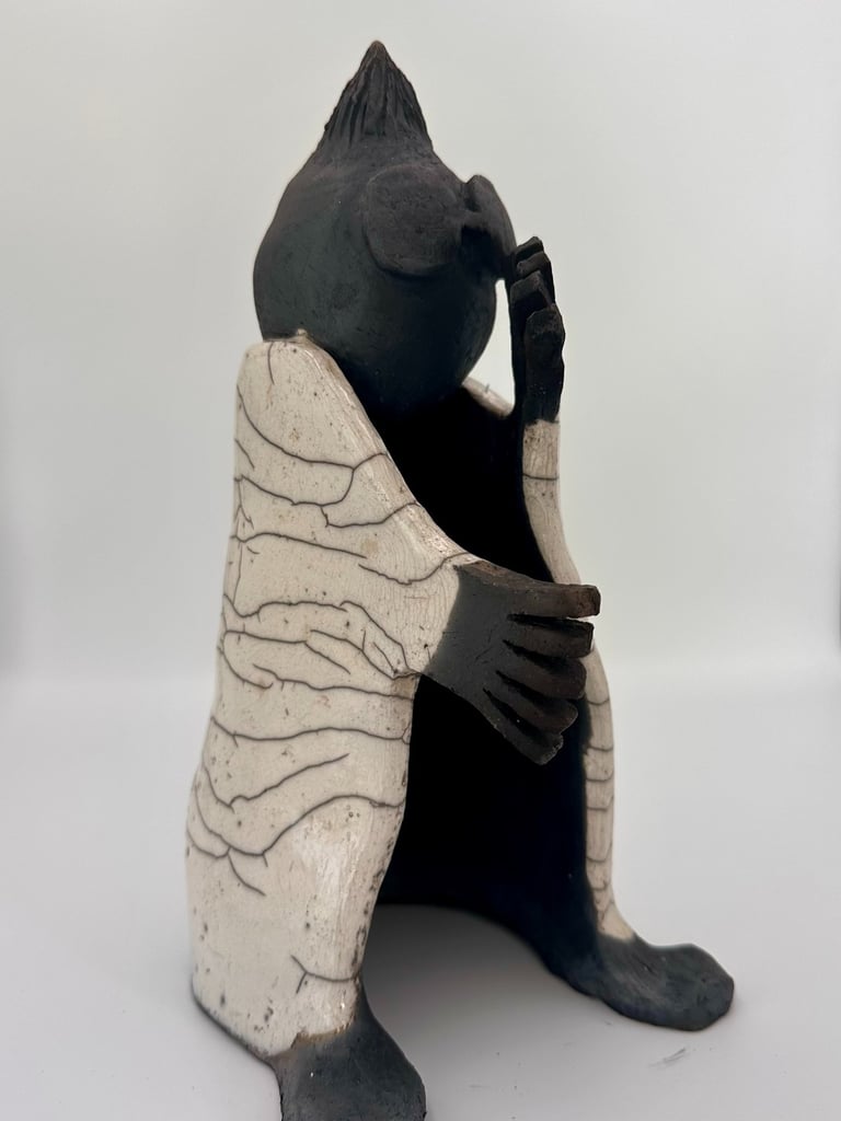 Handcrafted raku pottery sculpture featuring a stylized figure in a white crackle glaze robe.