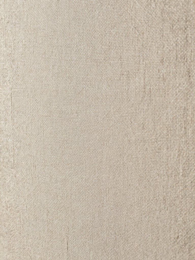 Extreme close-up of wallpaper weave texture, soft diffused north-light studio illumination revealing the grain and material weight of a linen-blend paper, warm neutral tones, abstract architectural surface detail, no people
