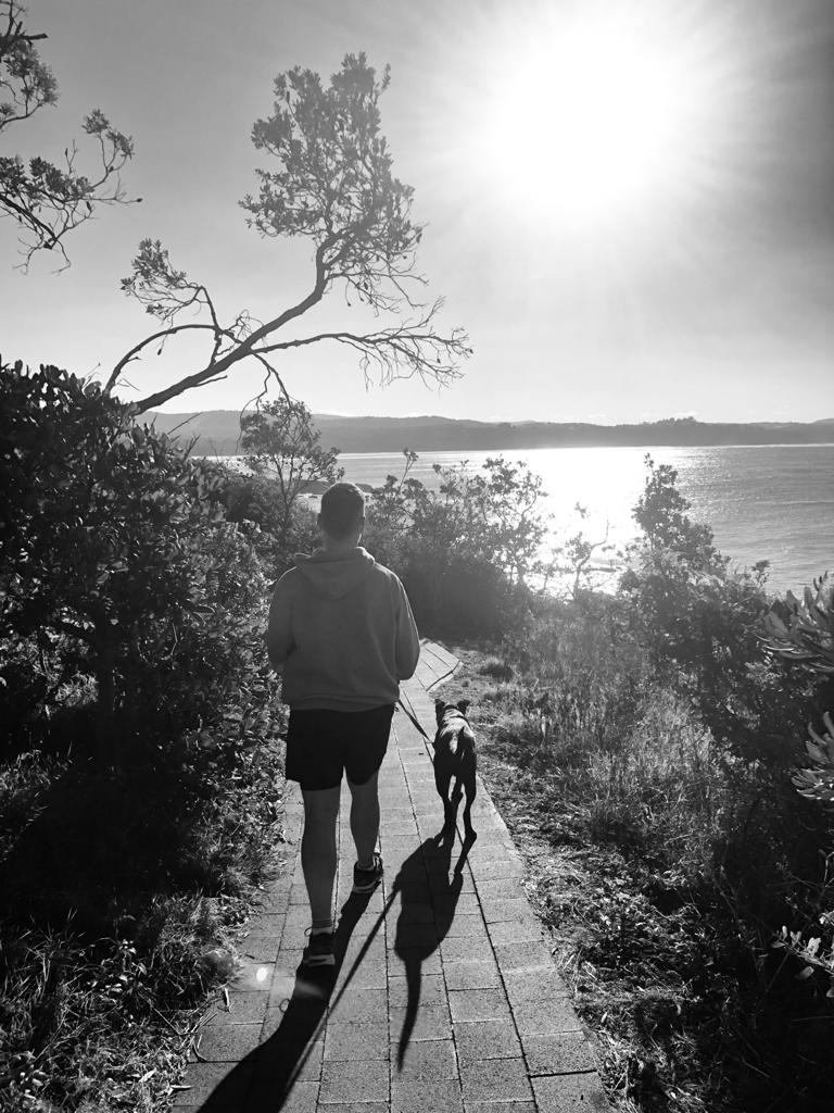 Tom Carolan walking his dog along a beach headland path