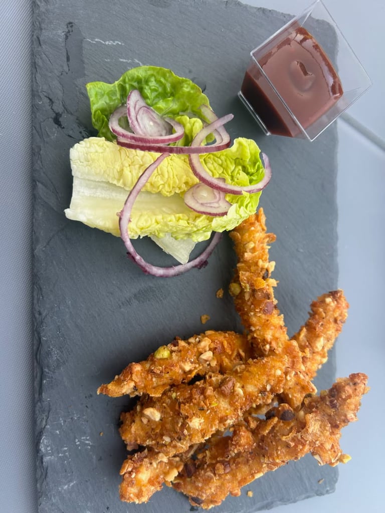 Assiettes de tapas variées et verres en terrasse de la brasserie vintage Le Loan.