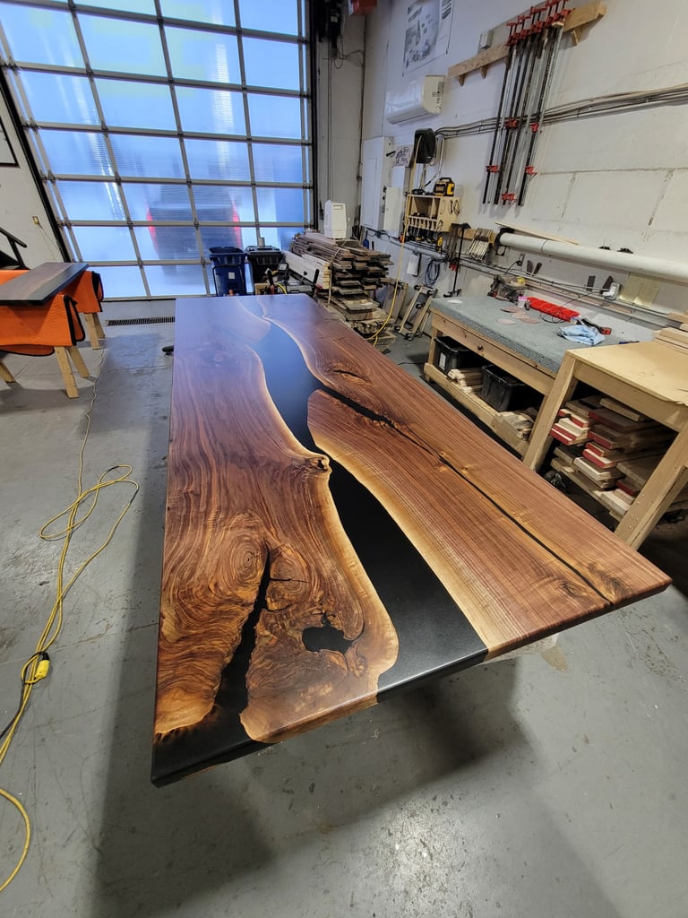 12ft x 4ft black walnut epoxy river boardroom table — in-shop production photo