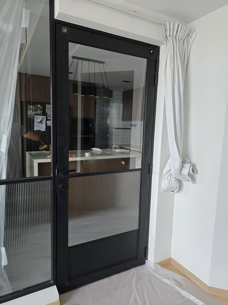 Modern bathroom interior featuring grey wall tiles, a frosted window, and a glass shower partition.