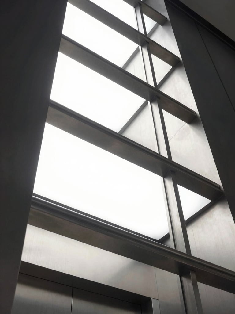 Low-angle looking up a modern illuminated elevator shaft, steel structure, crisp architectural lighting, cool metallic tones, 35mm lens