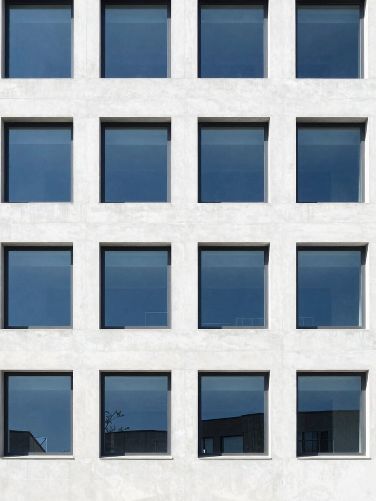 Minimalist architectural detail of a modern institutional concrete facade with structured geometric windows, bright high-key natural daylight, crisp shadows, deep blue accents, 35mm