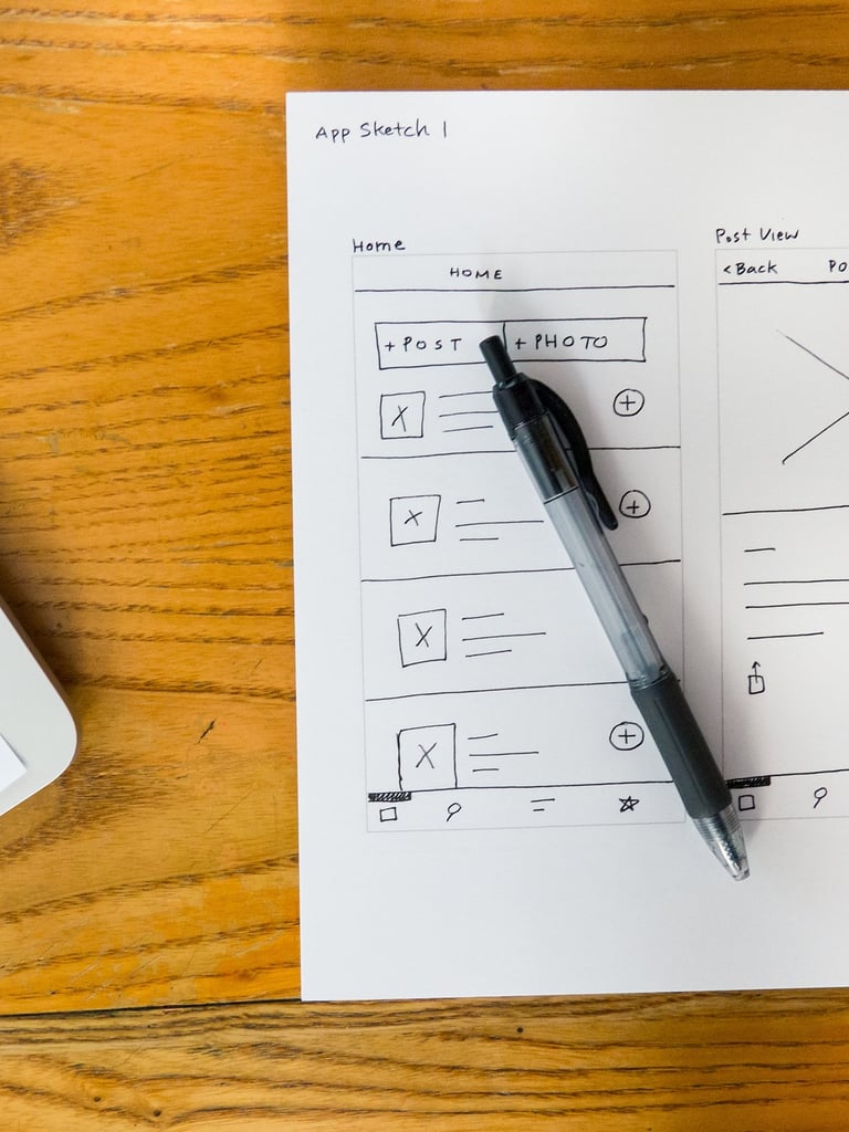 wireframe outline of customer experience design on a piece of paper and a pen