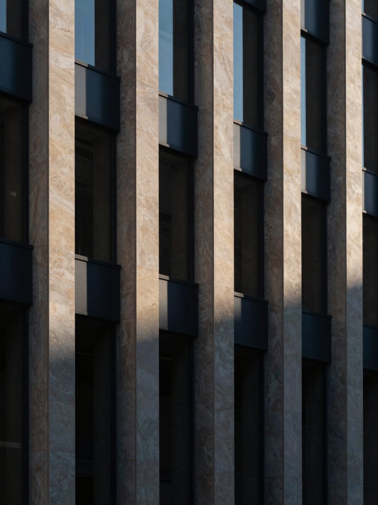 Sharp architectural details of a modern corporate limestone facade, dramatic shadows, cool-toned daylight, minimalist 35mm.