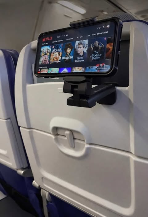Smartphone mounted on airplane seat tray table using a portable travel phone holder