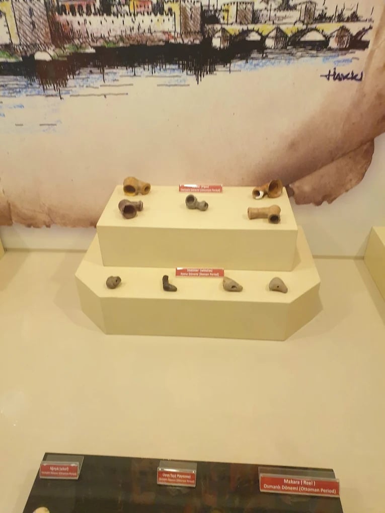 Ancient Roman and Ottoman period clay pipes and artifacts on display at a museum.