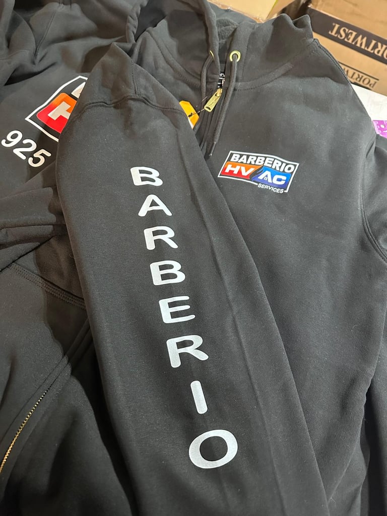 Custom black Barberio HVAC services workwear hoodies featuring printed sleeve logos and chest branding.