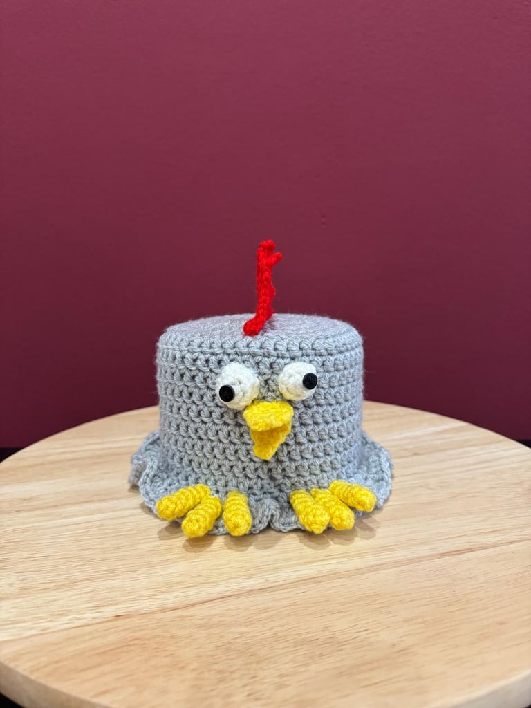 Klorollenhut Huhn in Grau mit verwackelten Augen. Lustige Geschenkidee oder Badezimmerdekoration