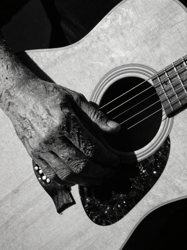 Close-up of weathered hands holding an old acoustic guitar, high-contrast chiaroscuro, deep shadows, 35mm film grain