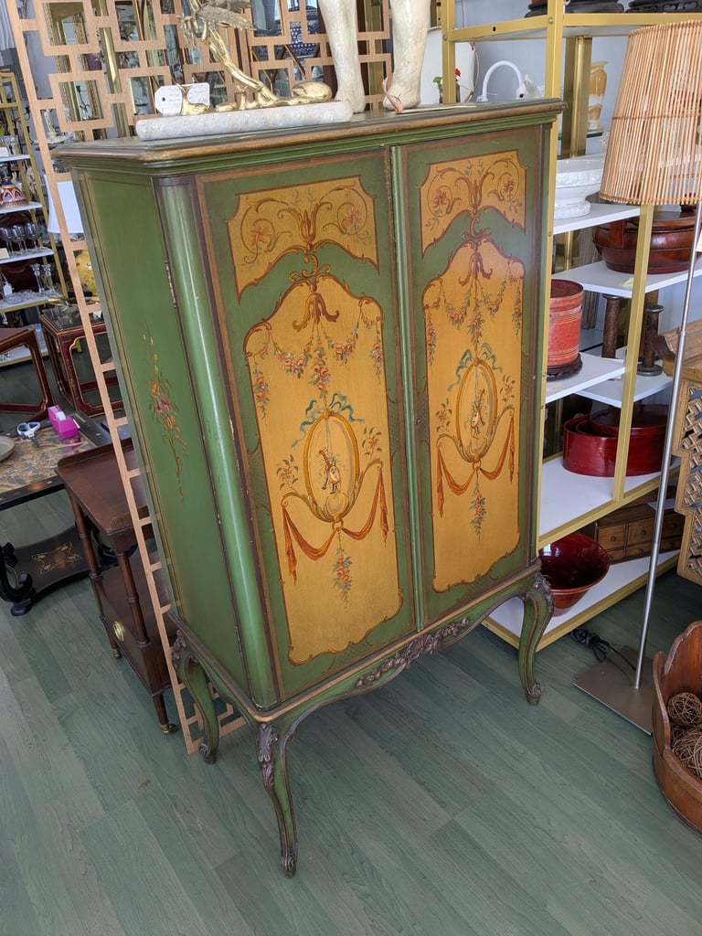 Antique green hand-painted cabinet with floral motifs and elegant cabriole legs.