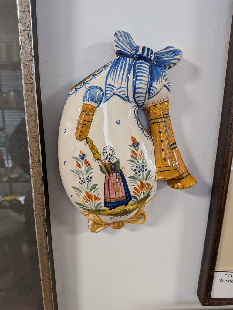 Vintage Quimper ceramic bagpipe wall hanging featuring a hand-painted Breton woman and floral motifs.