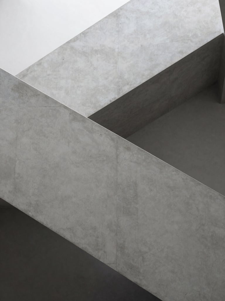 Architectural detail of a modern concrete staircase, clean lines, soft shadow play, minimalist luxury interior, monochromatic gray tones